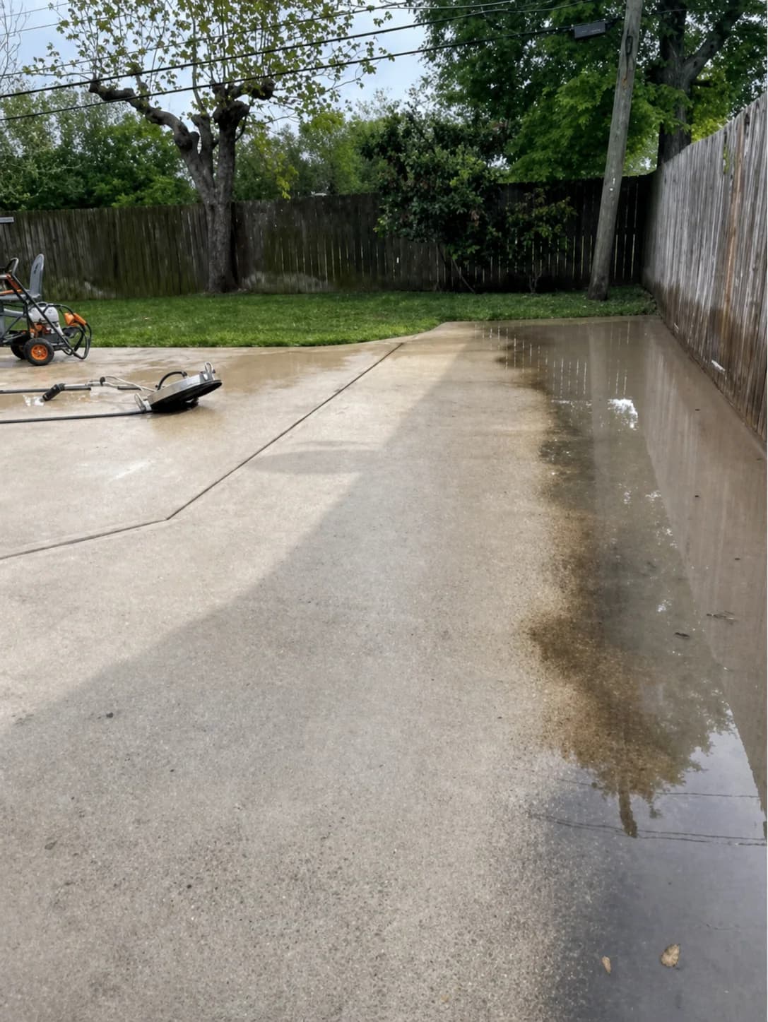 Pressure washing in progress with a visible dirty-to-clean transition on Houston concrete